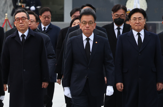 최상목 대통령 권한대행 부총리 겸 기획재정부 장관이 2025년 새해 첫날인 1일 국립서울현충원을 찾아 현충탑 참배를 마친 뒤 이동하고 있다. 최 권한대행 오른쪽 뒤로 이날 참배에 동행한 정진석 대통령 비서실장의 모습이 보인다. 연합뉴스