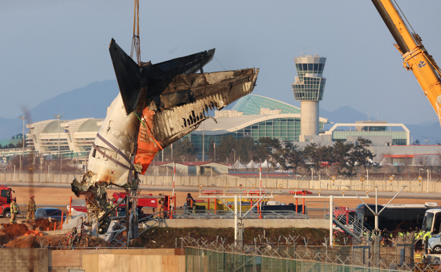 제주항공 여객기 참사 6일째인 3일 오후 전남 무안국제공항 사고 현장에서 소방당국 관계자들이 꼬리날개 부분을 크레인으로 인양하고 있다. 연합뉴스