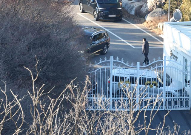 고위공직자범죄수사처가 윤석열 대통령의 체포영장 집행에 나선 지난 3일 서울 용산구 한남동 대통령 관저 경내에서 대통령 경호처 인원들이 철문 앞을 차량으로 막고 있다. 연합뉴스