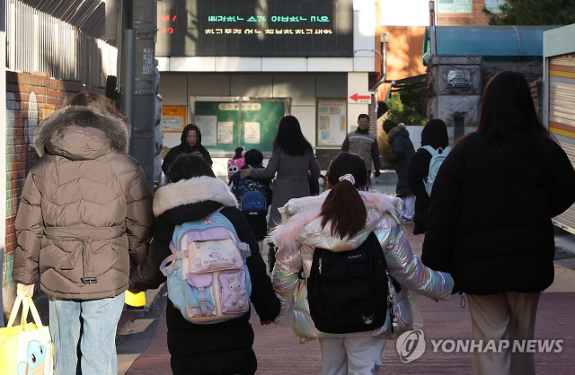 지난달 4일 오전 서울 한 초등학교 부근에서 학부모가 자녀들과 교문으로 향하고 있다. 연합뉴스