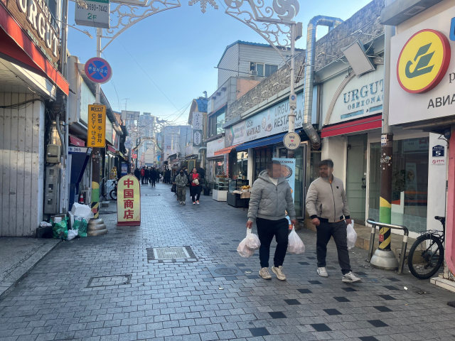 경남 김해시의 ‘글로벌 푸드타운’을 지나는 외국인들. 이경민 기자
