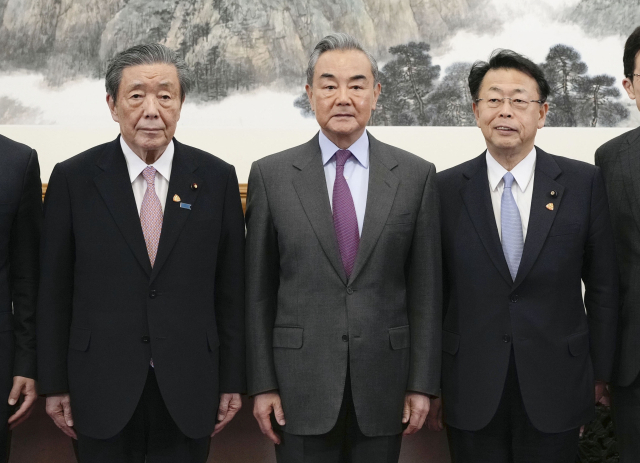 왕이(가운데) 중국 공산당 중앙외사판공실 주임 겸 외교부장이 14일 중국 베이징에서 일본 자민당 모리야마 히로시 간사장(왼쪽) 등과 기념촬영을 하고 있다. 연합뉴스