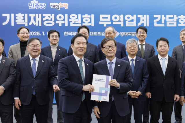 더불어민주당 정태호 의원(왼쪽)이 16일 오전 서울 강남구 무역센터에서 열린 민주당 기획재정위 소속 의원들과 무역업계와의 간담회에서 윤진식 무역협회장으로부터 무역 업계 애로사항이 담긴 건의 사항 책자를 전달받고 있다. 연합뉴스