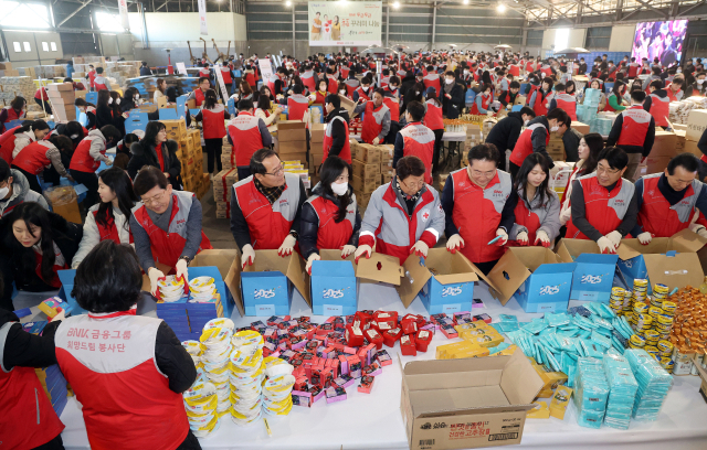 BNK금융그룹 빈대인 회장을 비롯한 전 계열사 임직원들이 18일 부산 중구 부산항 북항 제1부두 창고에서 취약계층에 전달할 복꾸러미를 만들고 있다. 정종회 기자 jjh@