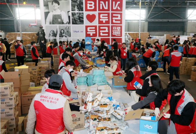 BNK금융그룹 전 계열사 임직원들이 18일 부산 중구 부산항 북항 제1부두 창고에서 취약계층에 전달할 복꾸러미를 만들고 있다. 정종회 기자 jjh@