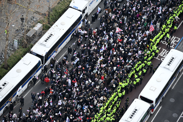 내란 우두머리 혐의로 체포된 윤석열 대통령의 구속 전 피의자심문(영장실질심사)이 열린 18일 서울 마포구 서울서부지방법원 앞에서 윤 대통령 지지자들이 집회를 하고 있다. 연합뉴스