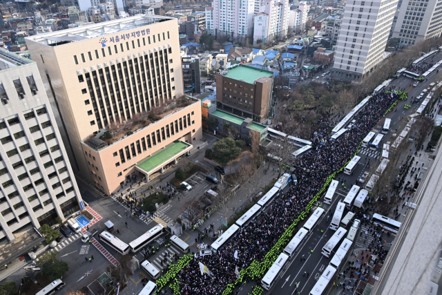 내란 우두머리 혐의로 체포된 윤석열 대통령의 구속 전 피의자심문(영장실질심사)이 열린 18일 서울 마포구 서울서부지방법원 앞에서 윤 대통령 지지자들이 집회를 하고 있다. 연합뉴스