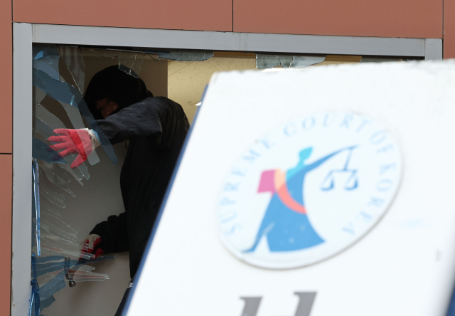 19일 윤석열 대통령 구속 소식을 들은 일부 윤 대통령 지지자들이 불법폭력사태를 일으킨 서울 마포구 서울서부지방법원에서 한 작업자가 복구 작업을 하고 있다. 연합뉴스