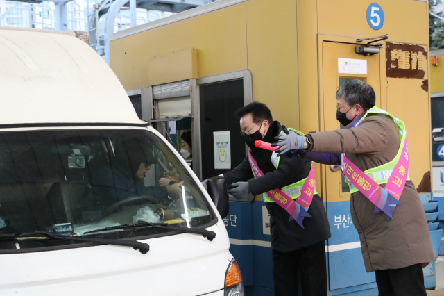 부산시설공단 이성림(가운데) 이사장과 박태웅(오른쪽) 도시기반본부장이 지난 20일 광안대교 수영강변요금소에서 스마트톨링 안내문과 홍보기념품을 전달하고 있다. 부산시설공단 제공