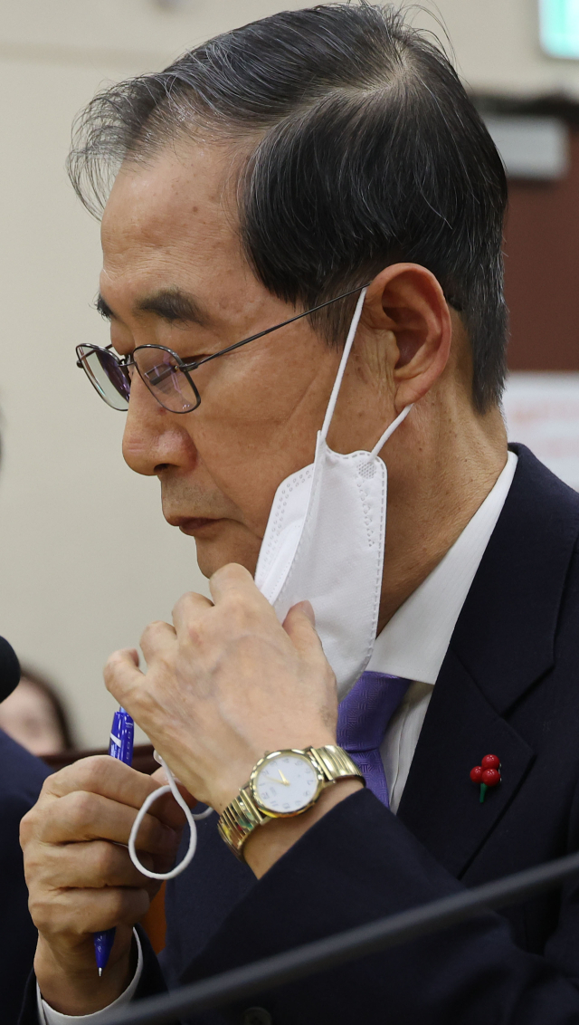 한덕수 국무총리가 22일 국회에서 열린 ‘윤석열 정부의 비상계엄 선포를 통한 내란 혐의 진상규명 국정조사 특별위원회’ 1차 청문회에서 답변하기 위해 마스크를 벗고 있다. 연합뉴스