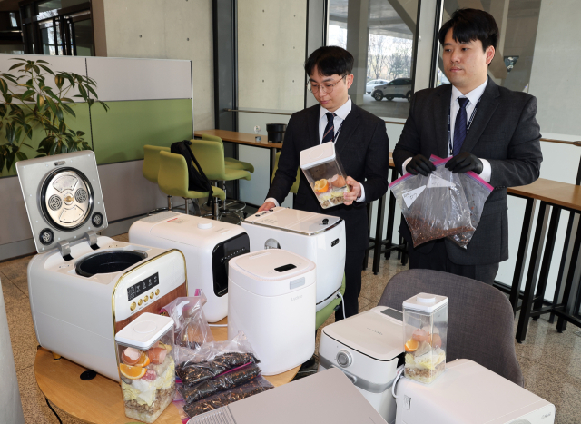 한국소비자원이 23일 오전 정부세종청사 공정위 기자실에서 시중 유통 중인 주요 음식물처리기 브랜드 9개 제품의 품질·안전성·경제성 등을 시험 평가한 비교정보를 발표했다. 사진은 직원들이 해당 제품을 살펴보는 모습. 연합뉴스
