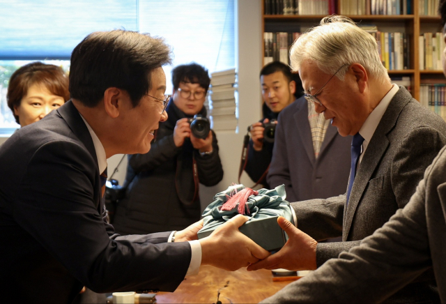 문재인 전 대통령이 30일 경남 양산 평산마을 사저를 찾은 이재명 더불어민주당 대표로부터 설 선물을 받고 있다. 더불어민주당 제공.