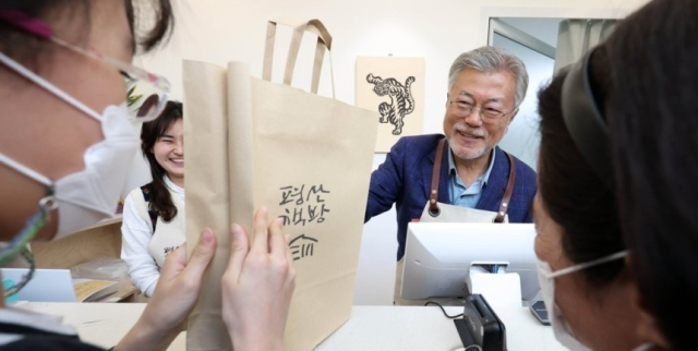 문재인 전 대통령이 지난달 26일 오후 경남 양산시 하북면 자신의 책방 '평산책방'에서 계산 업무를 하며 손님 책에 사인을 하고 있다. 연합뉴스