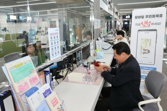 나동연 양산시장이 14일 모바일 주민등록증 서비스 홍보를 위해 삼성동 행정복지센터를 찾아 모바일 주민등록증을 발급받고 있다. 김태권 기자