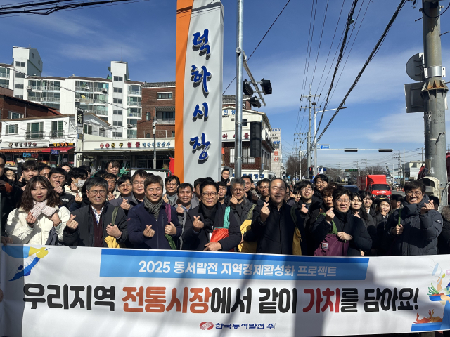 25일 울산시 울주군 덕하시장에서 진행된 '전통시장 가는날' 장보기 행사에서 동서발전 임직원이 단체사진을 촬영하는 모습. 동서발전 제공