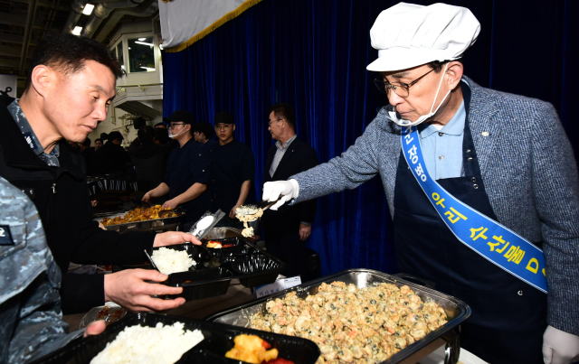 노동진 수협중앙회장(오른쪽)이 지난 10일 경남 진해에 소재한 해군 작전사령부 직할 5전단마라도함에서 열린 '수산물 데이' 행사에서 해군 장병에게 보양 수산물 중심의 점심 특식을 배식하고 있다. 수협 제공
