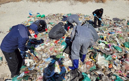 쓰레기를 뒤지는 환경미화원의 모습. 연합뉴스