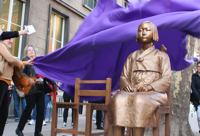 8일(현지 시간) 독일 쾰른 나치기록박물관 앞에서 열린 ‘평화의 소녀상’ 제막식에서 전시 관계자들이 막을 걷어내고 있다. 연합뉴스