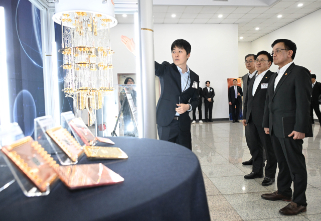 최상목 대통령 권한대행 부총리 겸 기획재정부 장관이 12일 대전 한국표준과학연구원에서 열린 양자전략위원회 1차 회의 참석에 앞서 양자컴퓨터와 핵심소자인 양자 프로세서 유닛(QPU) 설명을 듣고 있다. 연합뉴스