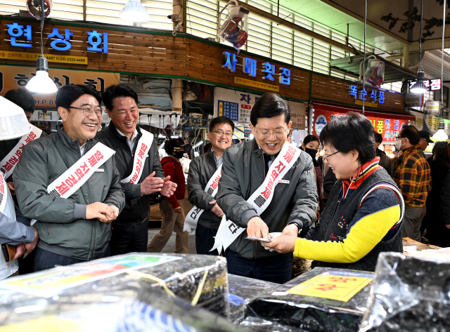 BNK금융지주 빈대인 회장(오른쪽에서 두번째) 등 그룹 경영진이 14일 부산 부전시장을 찾아 창립 14주년 기념 이벤트로 전통시장 상품 구매와 식당 선결제를 진행했다. BNK 제공
