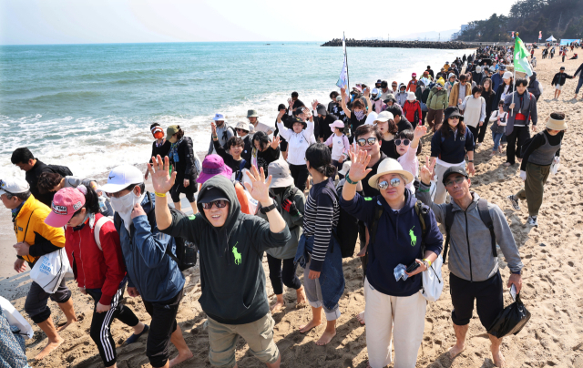 22일 오후 부산 기장군 임랑해수욕장에서 열린 ‘맨발걷기 좋은 도시 부산 세븐비치 어싱 챌린지 <5>임랑’ 행사에서 참가자들이 바닷가를 걸으며 맨발 걷기의 묘미를 즐기고 있다. 정종회 기자 jjh@