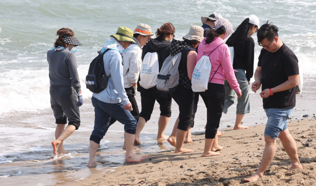 22일 오후 부산 기장군 임랑해수욕장에서 열린 ‘맨발걷기 좋은 도시 부산 세븐비치 어싱 챌린지 임랑’ 행사에서 참가자들이 바닷가를 걸으며 맨발 걷기의 묘미를 즐기고 있다. 정종회 기자 jjh@