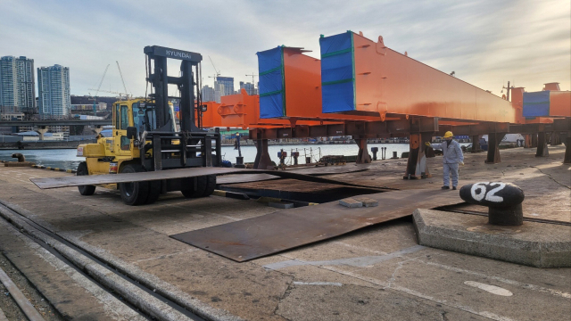 자성대부두로 옮겨지는 컨테이너크레인(위)과 자성대부두에서 조립 작업 중인 야드크레인. BPA 제공