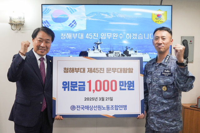 선원노련 박성용 위원장이 지난 21일 청해부대 환송식에서 문무대왕함 임태웅 함장에게 위문금 1000만 원을 증정하고 화이팅을 외치고 있다. 선원노련 제공