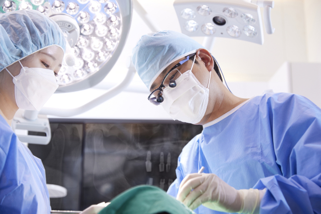 골다공증 약을 복용할 경우 임플란트나 턱뼈 골절수술을 받을 때 골 유착 장애와 골 괴사 위험이 있으므로 주의해야 한다. 사진은 김병수 메디스치과 원장이 임플란트 시술을 하고 있는 모습. 메디스치과 제공