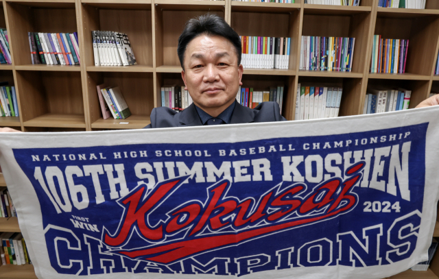 지난해 일본 여름 고시엔에서 우승한 교토국제고 백승환 교장이 24일 <부산일보>를 방문해 야구부 응원 수건을 펼쳐 보이고 있다. 김종진 기자 kjj1761@