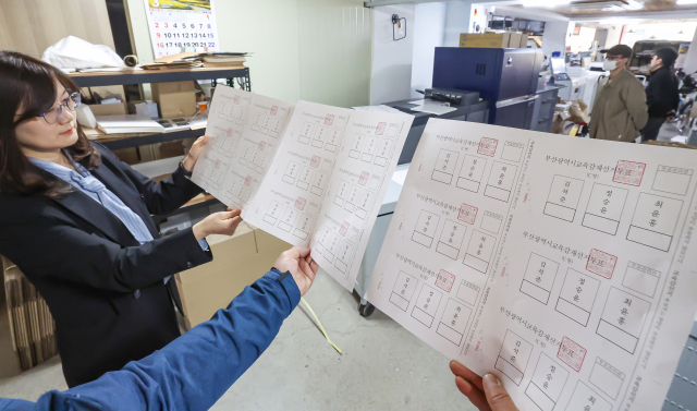 4·2 부산교육감 재선거를 앞두고 지난 24일 부산 부산진구의 한 인쇄소에서 부산시선거관리위원회 직원 등이 인쇄된 투표용지를 확인하고 있다. 김종진 기자 kjj1761@