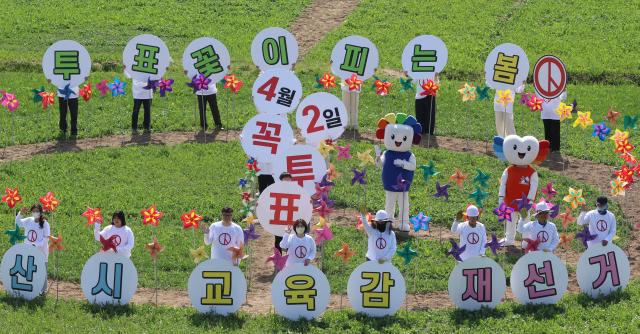 4·2 재보궐선거를 앞두고 26일 부산 강서구 대저생태공원 유채꽃 경관 단지에서 부산시선거관리위원회가 유채밭에 조성된 기표모양 꽃길에서 투표참여 홍보 퍼포먼스를 펼치고 있다. 연합뉴스