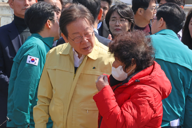 더불어민주당 이재명 대표가 29일 경북 영덕군 영덕읍 노물리에서 산불 피해를 본 주민의 얘기를 듣고 있다. 연합뉴스