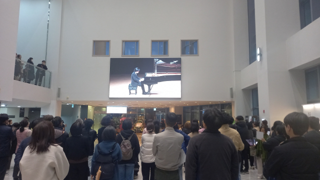 3월 30일 오후 7시 통영국제음악당 콘서트홀에서 임윤찬 피아노 리사이틀이 진행되는 가운데 공연장 로비에는 미처 입장하지 못한 청중들이 대형 모니터로 공연을 지켜보고 있다. 독자 제공