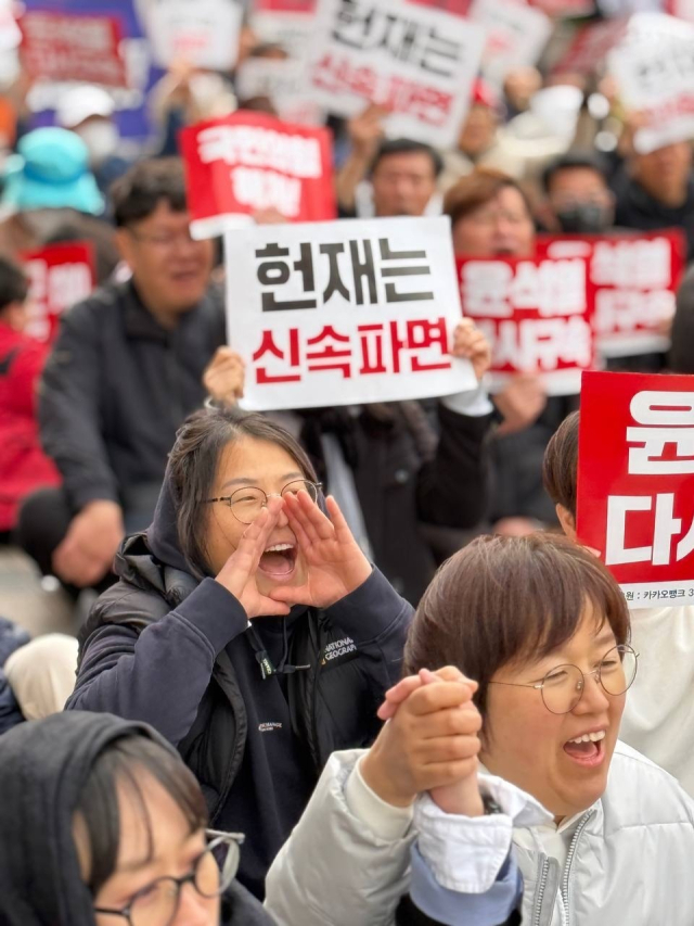 민주노총 등 시민·사회단체로 구성된 윤석열즉각파면 울산운동본부가 지난달 29일 오후 롯데백화점 울산점 광장에서 시민대회를 열고 있다. 참가자들이 '헌재는 신속파면'이 적힌 피켓을 들어보이고 있다. 민주노총 울산본부 제공