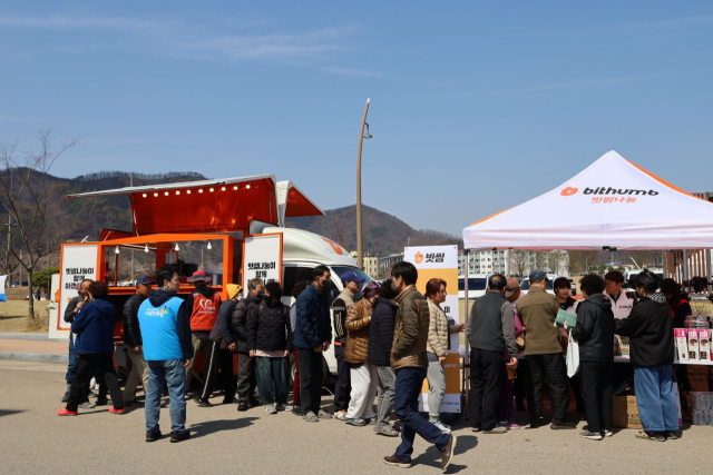 지난달 29일 빗썸나눔 임직원들이 영덕국민체육센터 앞에서 주민들에게 음식과 생필품 등 구호물품을 나누고 있다. 빗썸 제공