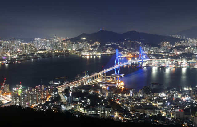 오후 7시 30분이 지나면 부산항대교에 불빛이 들어온다. 낮과 밤이 교차하는 ‘매직 아워’. 어둠이 짙어지기 전 검푸른 하늘과 바다 사이 원도심은 화려한 불빛으로 물든다. 사진은 봉래산 불로문 전망대에서 부산항대교를 바라본 모습. 이재찬 기자chan@