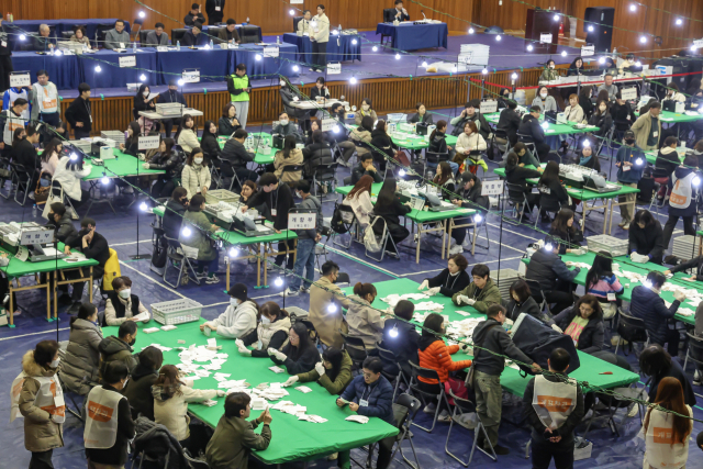 부산 남구 부경대학교 대연캠퍼스 체육관에 마련된 개표소에서 개표 사무원들이 투표지를 분류하고 있는 모습. 김종진 기자 kjj1761@