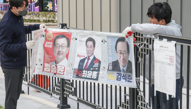3일 오전 부산 연제구에서 부산시선거관리위원회 관계자들이 부산시교육감 재선거 벽보를 철거하고 있다. 김종진 기자 kjj1761@