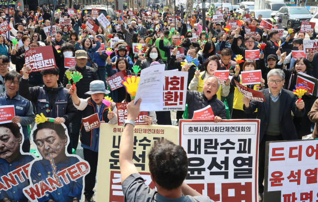 충북비상시국회의 소속 회원들과 시민들이 4일 오전 충북도청 앞에서 헌법재판소의 윤석열 대통령 파면 선고 결과를 듣고 환호하고 있다. 연합뉴스