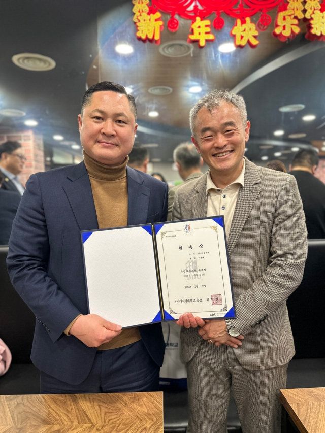 이정태(왼쪽) 대표가 박기오 부산디지털대 외식경영학과장으로부터 특임교수 위촉장을 받고 있다.