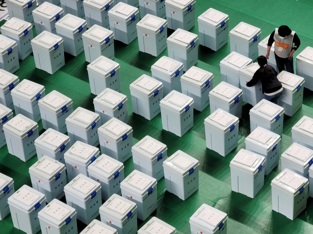 윤석열 전 대통령이 지난 4일 파면되면서 제21대 대통령 선거가 오는 6월 3일 치러진다. 직전 제20대 대통령 선거일인 2022년 3월 9일 투표소에서 개표 사무원들이 투표함을 옮기고 있는 모습 . 연합뉴스