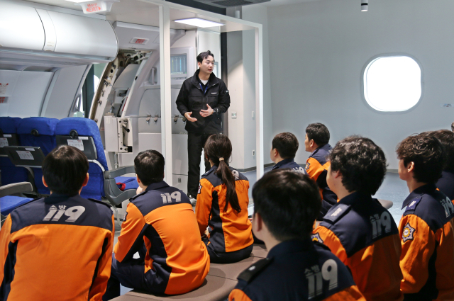 지난 9일 에어부산 사옥 훈련시설에서 부산소방재난본부 소방관들이 비상구 조작법을 배우고 있다. 에어부산 제공.