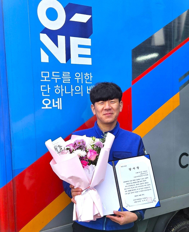 CJ대한통운 택배기사 최기원 씨가 서울시 서대문구 홍제동에서 화재 현장 시민 대피 공로로 수령한 감사장을 들고 기념사진 촬영을 하고 있다. CJ대한통운 제공