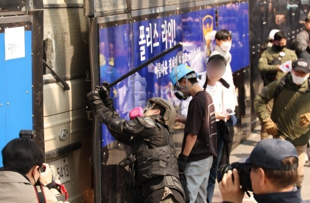 4일 서울 종로구 헌법재판소 인근에서 윤석열 대통령 지지 집회 참가자 중 한 명이 헌재의 윤 대통령 파면 결정에 경찰이 세운 가벽 사이로 보이는 차량을 부수고 있다. 연합뉴스