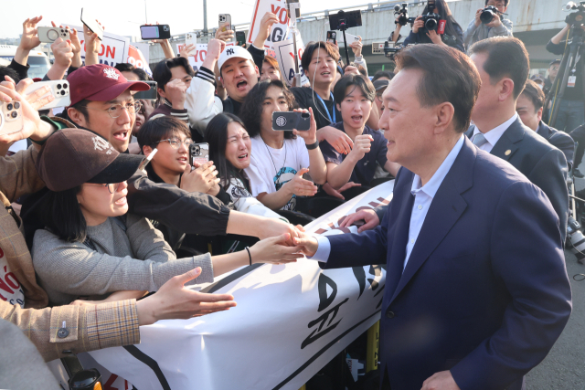 윤석열 전 대통령이 11일 오후 서울 용산구 한남동 대통령 관저를 떠나기 앞서 정문 앞에서 지지자들과 인사를 나누고 있다. 연합뉴스