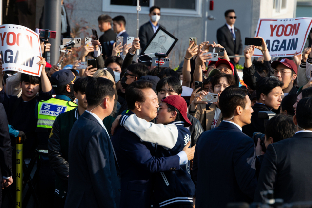 윤석열 전 대통령이 11일 서울 용산구 한남동 관저에서 나와 서초동 사저로 향하기 전 한 지지자와 포옹하고 있다. 연합뉴스
