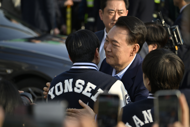윤석열 전 대통령이 11일 서울 용산구 한남동 관저에서 나와 서초동 사저로 향하기 전 지지자들과 포옹하고 있다. 연합뉴스