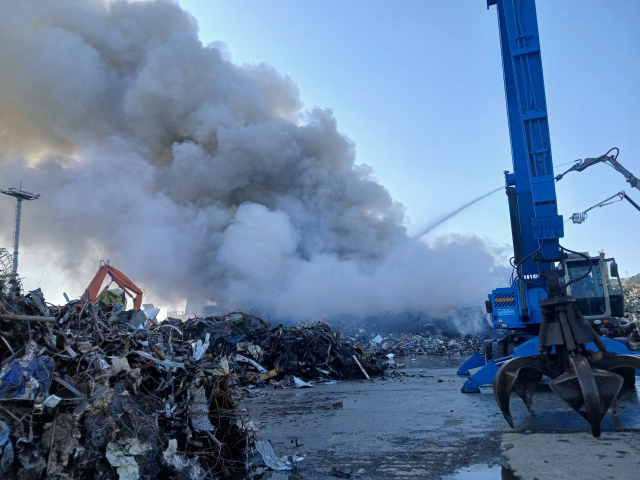 12일 부산 사하구 구평동 YK스틸 야적장에서 불이 나면서 13일에도 소방 당국이 진화 작업을 진행하고 있다. 부산소방재난본부 제공