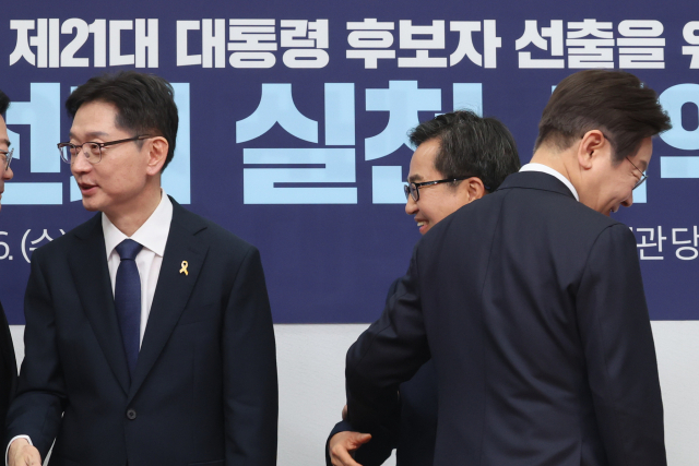 더불어민주당 대선후보 경선 주자인 이재명 전 대표(오른쪽), 김경수 전 경남지사(왼쪽), 김동연 경기지사가 16일 서울 여의도 국회에서 열린 공명선거 실천 서약식을 마친 뒤 인사를 나누고 있다. 연합뉴스